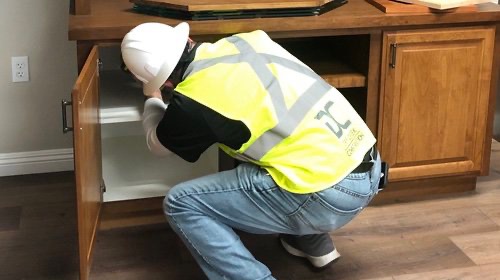 Dry Creek Construction employee installing cabinets.